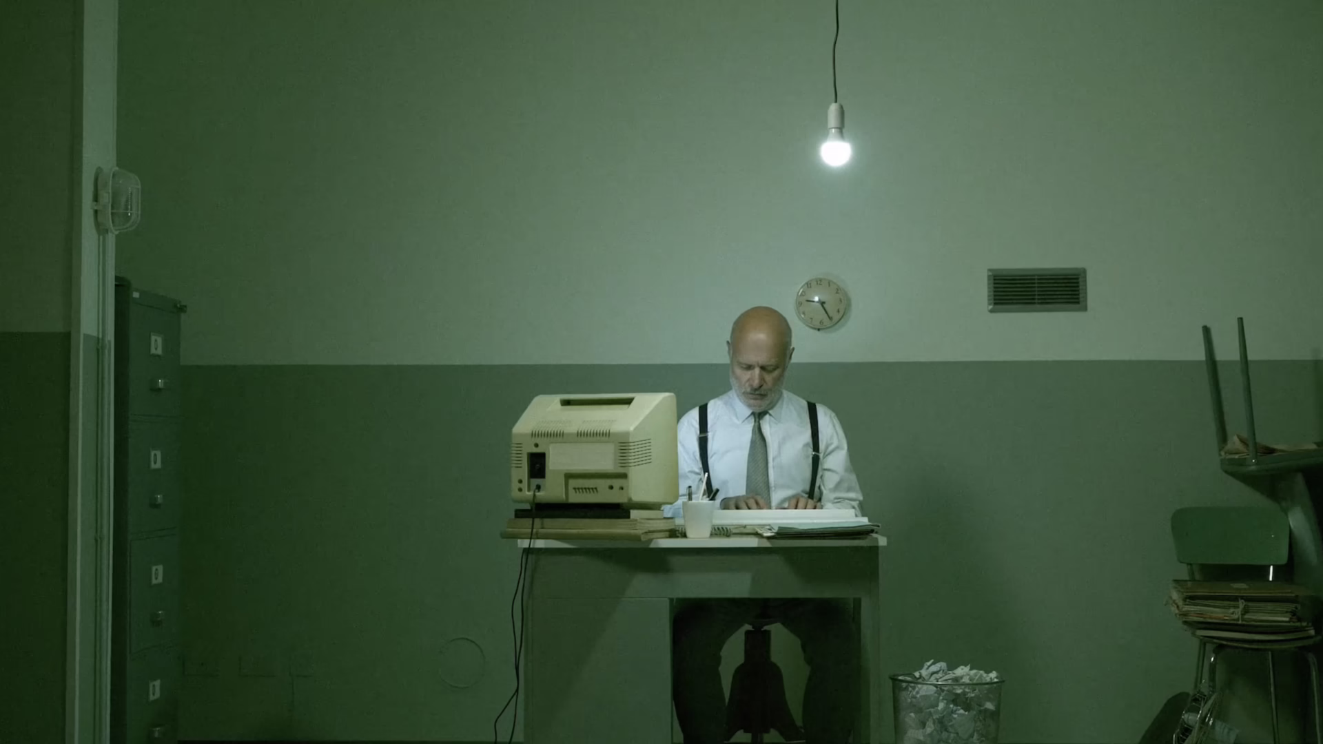 Man on a computer in a dimly lit room