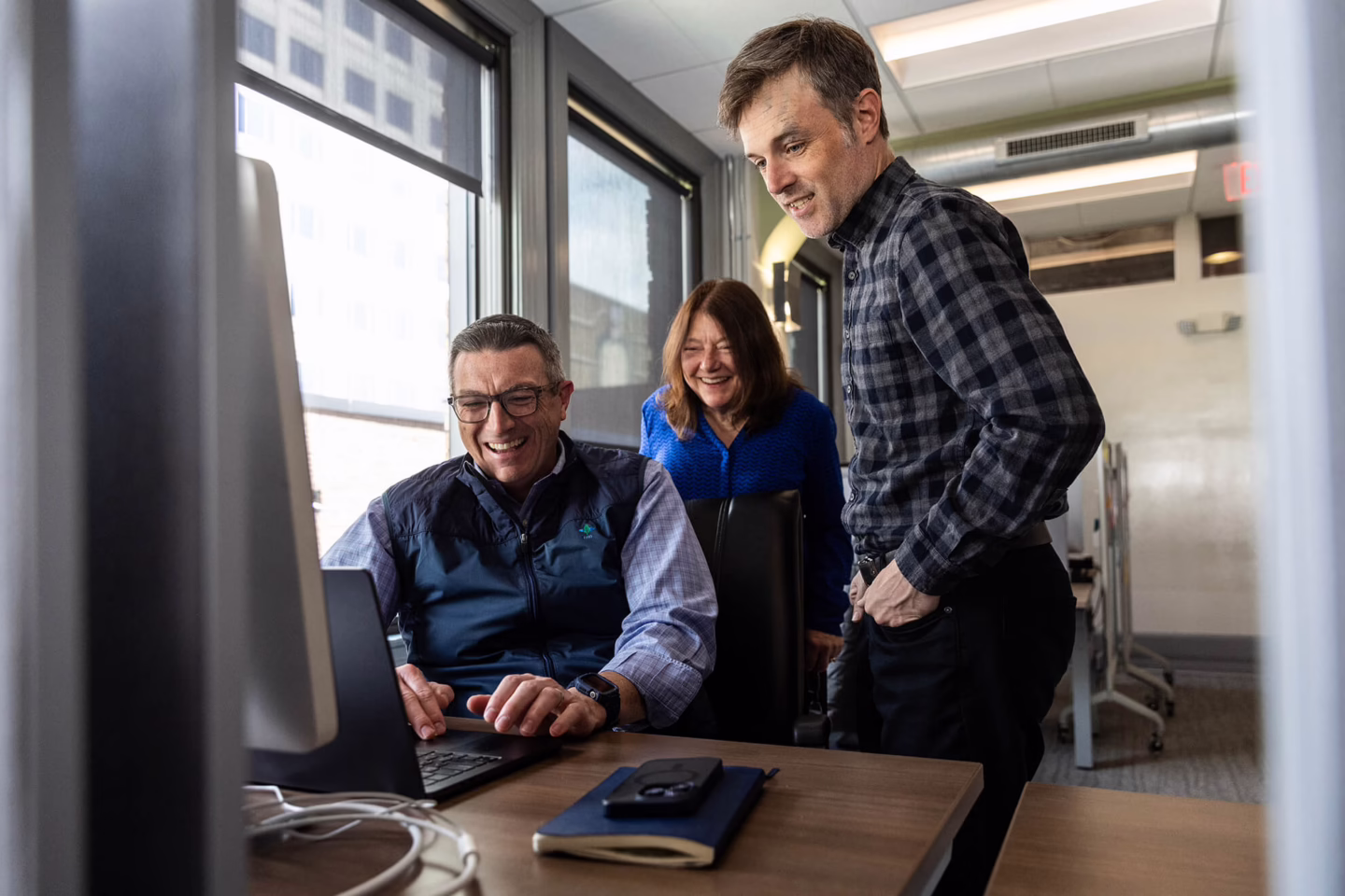 People looking at a computer screen and smiling