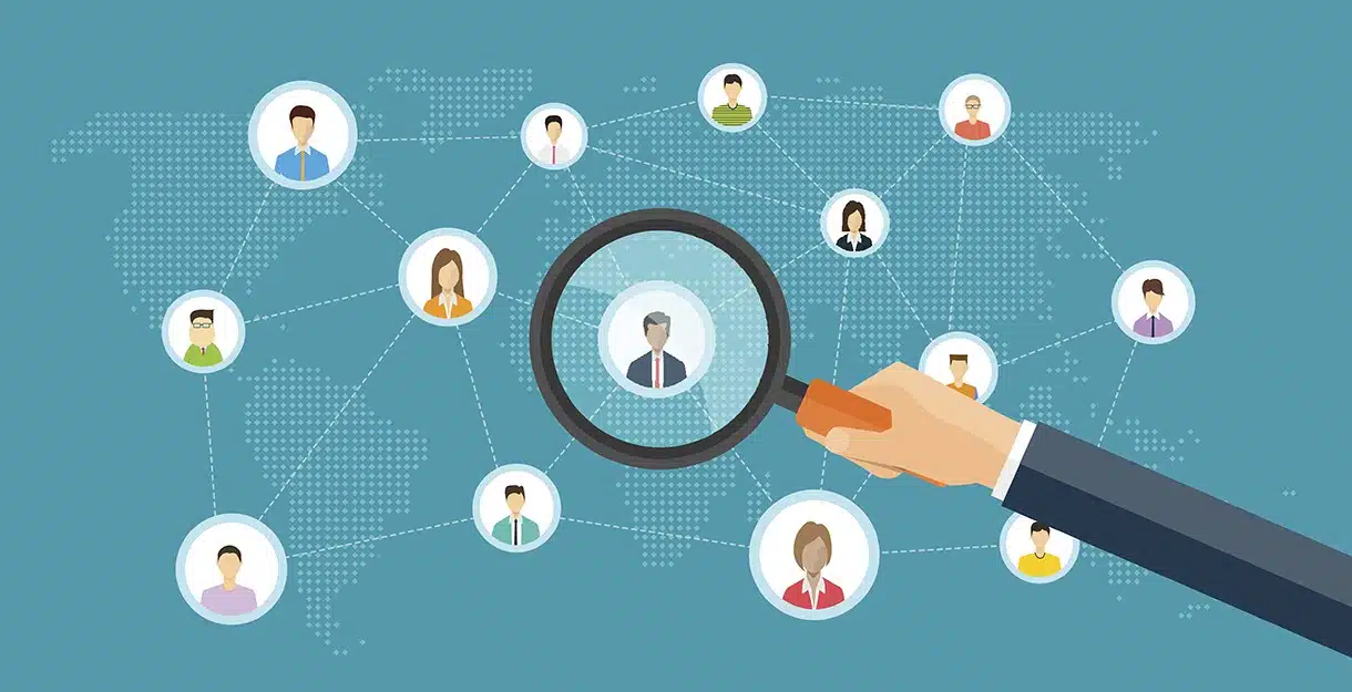 flat business marketing research concept A digital illustration of a hand holding a magnifying glass over a network of global profile icons on a blue background.