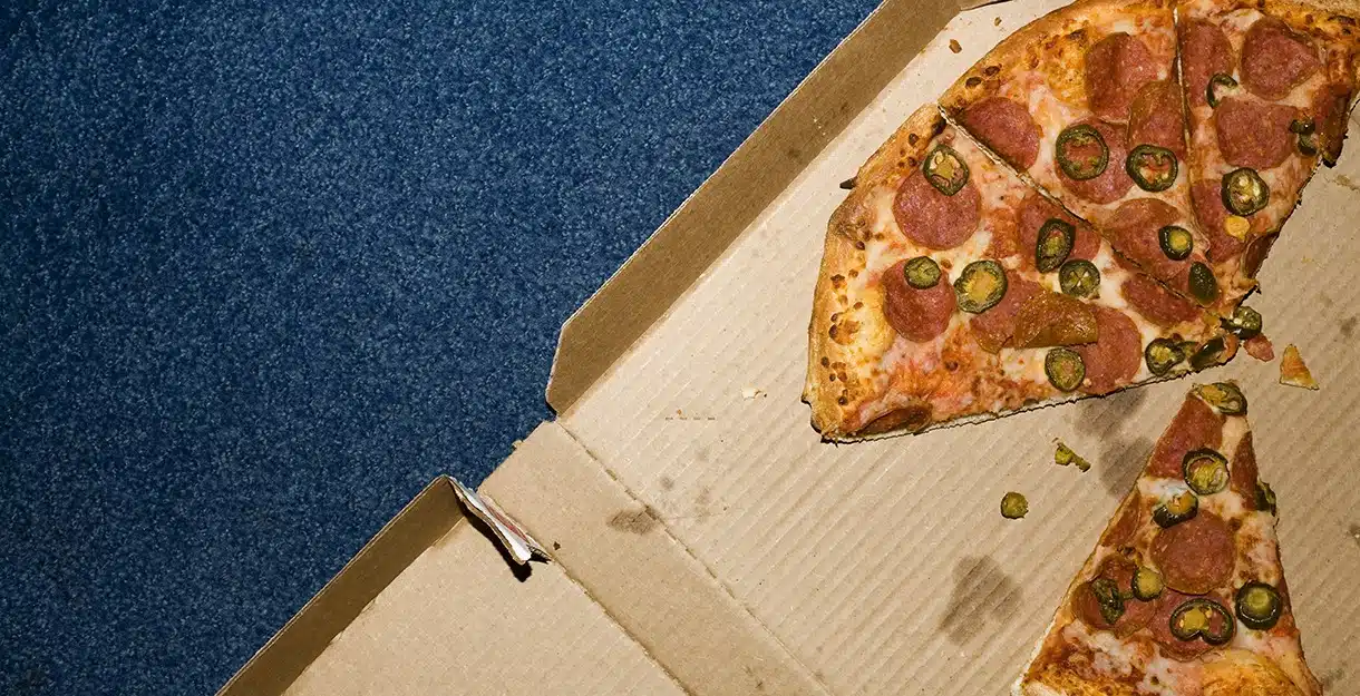 Pizza slices in an open cardboard box.