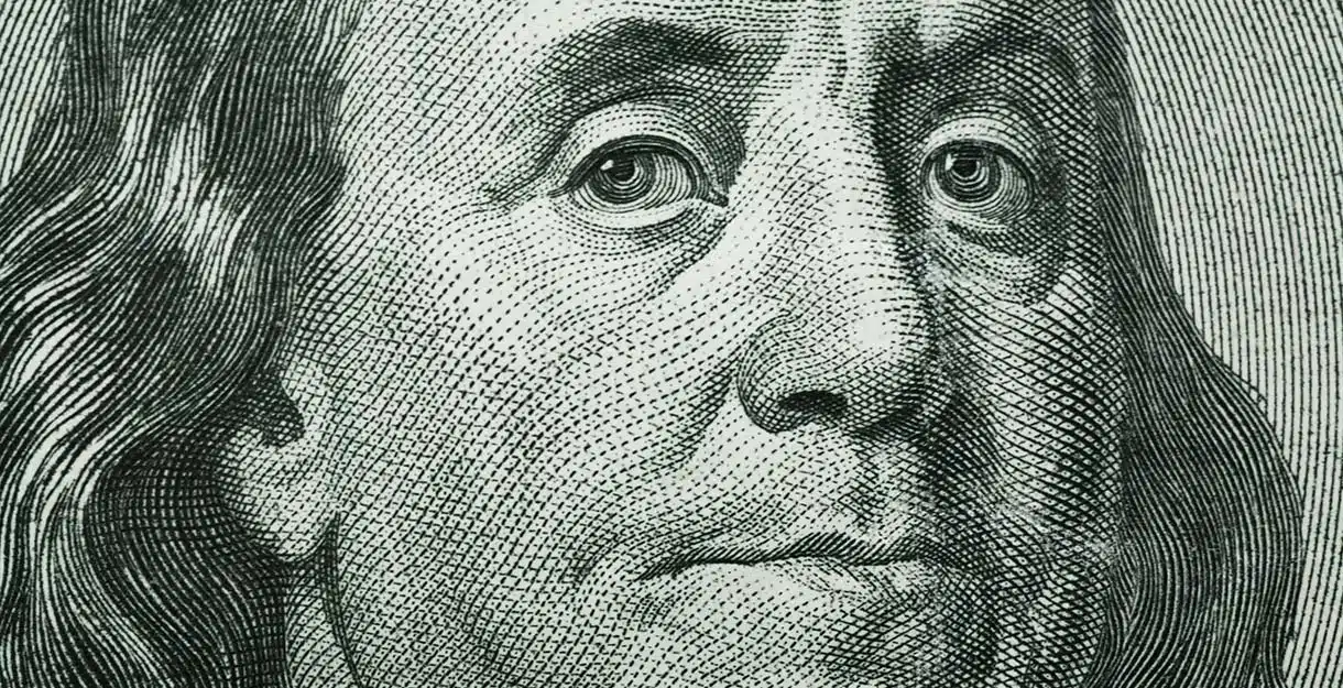 A close-up, engraved portrait of Benjamin Franklin as seen on a United States one-hundred-dollar bill.