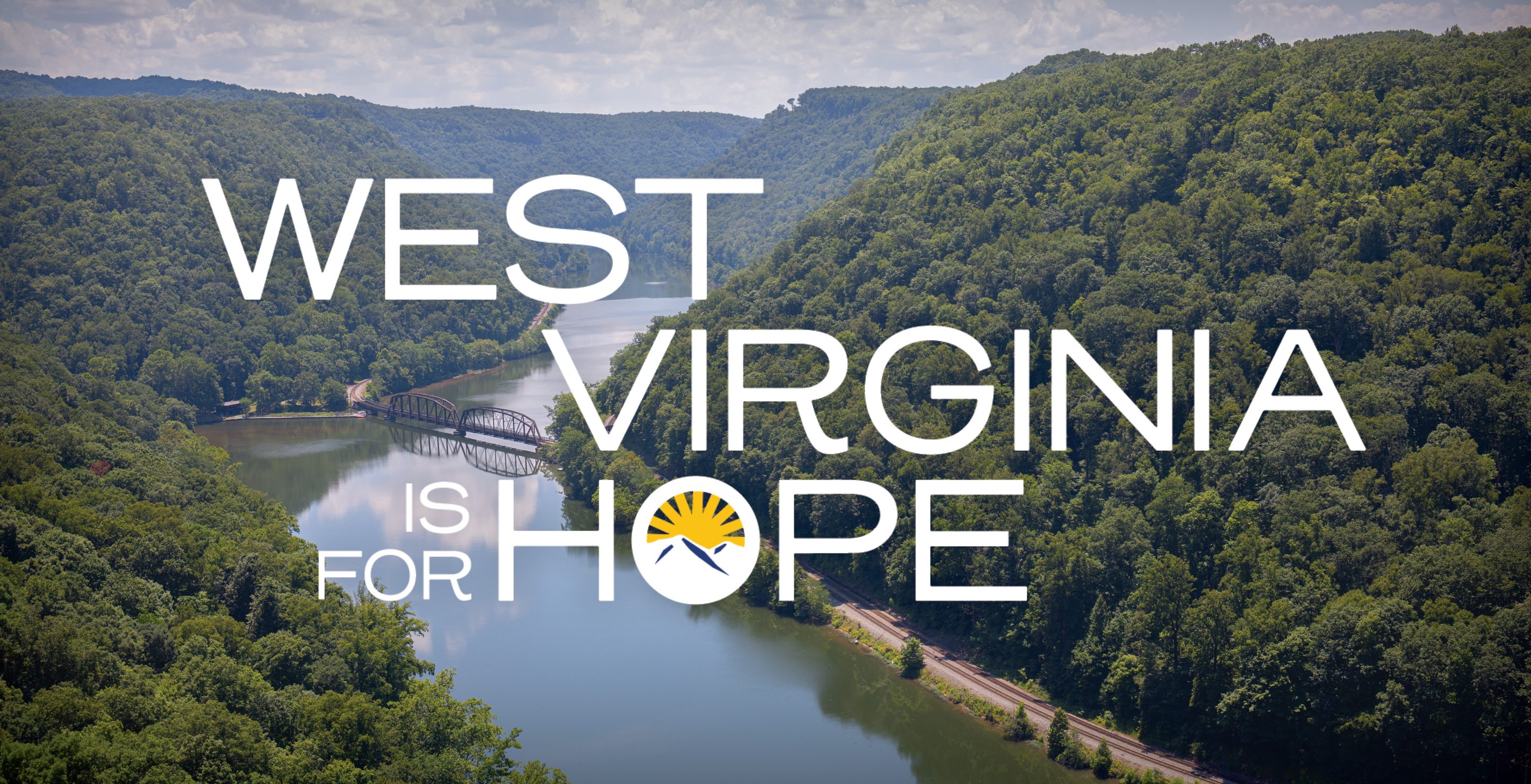 West Virginia is for Hope logo An aerial landscape of a river winding through lush green mountains with the logo for West Virginia is for Hope.